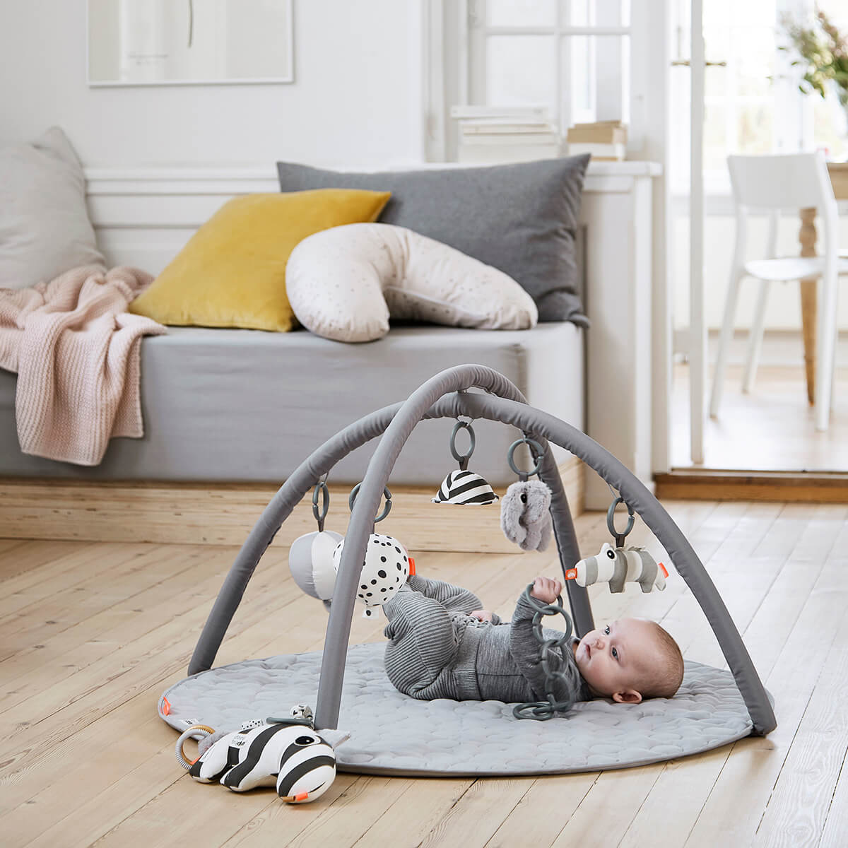 Child using a Done by Deer Activity play mat